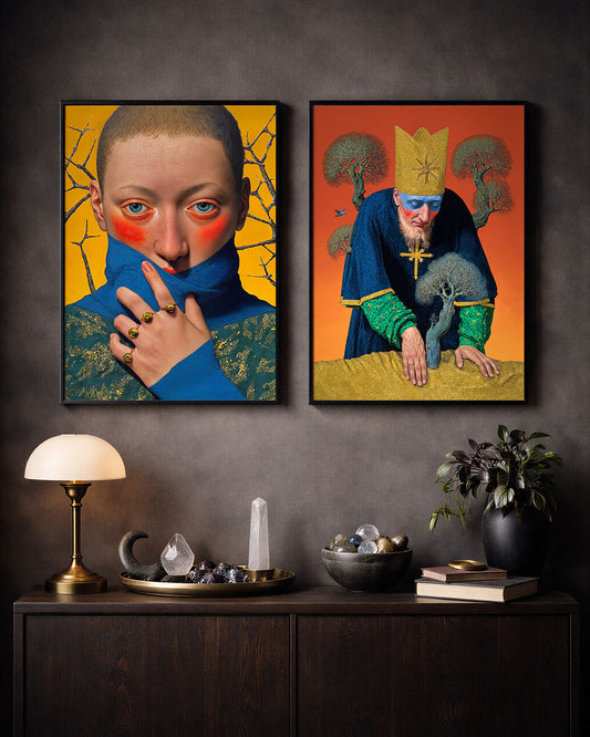 Two framed surreal art posters hanging above a dark wooden console table with crystals, books and a lamp in a moody modern interior.