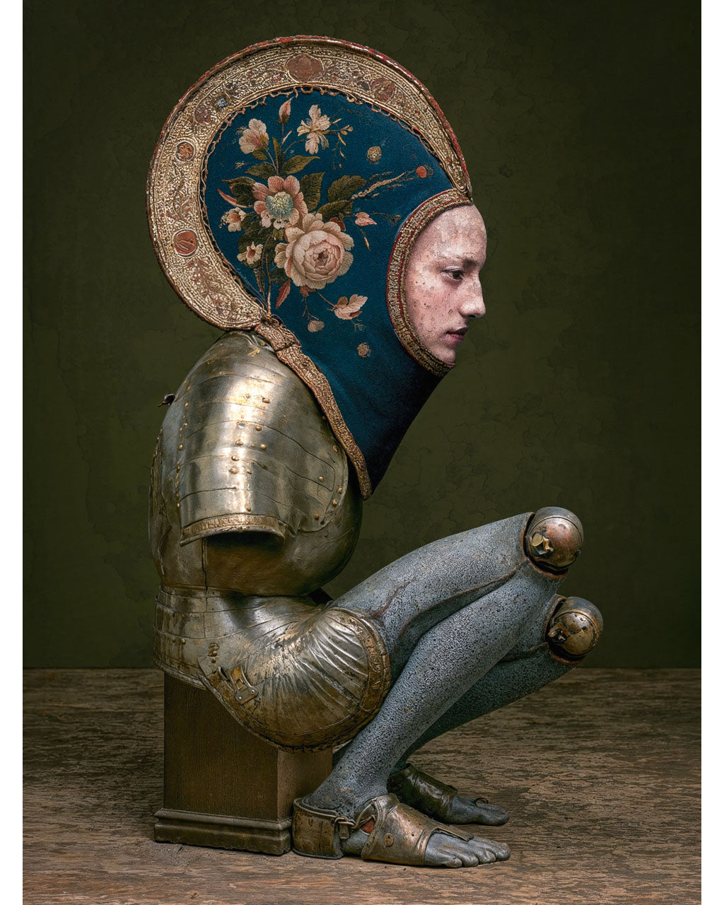 Surreal armoured figure without arms wearing an intricate floral headpiece