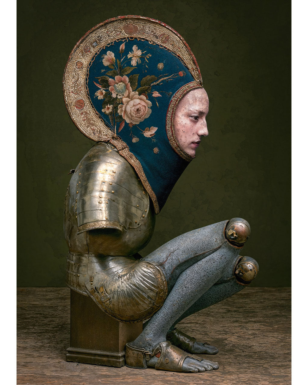 Surreal armoured figure without arms wearing an intricate floral headpiece