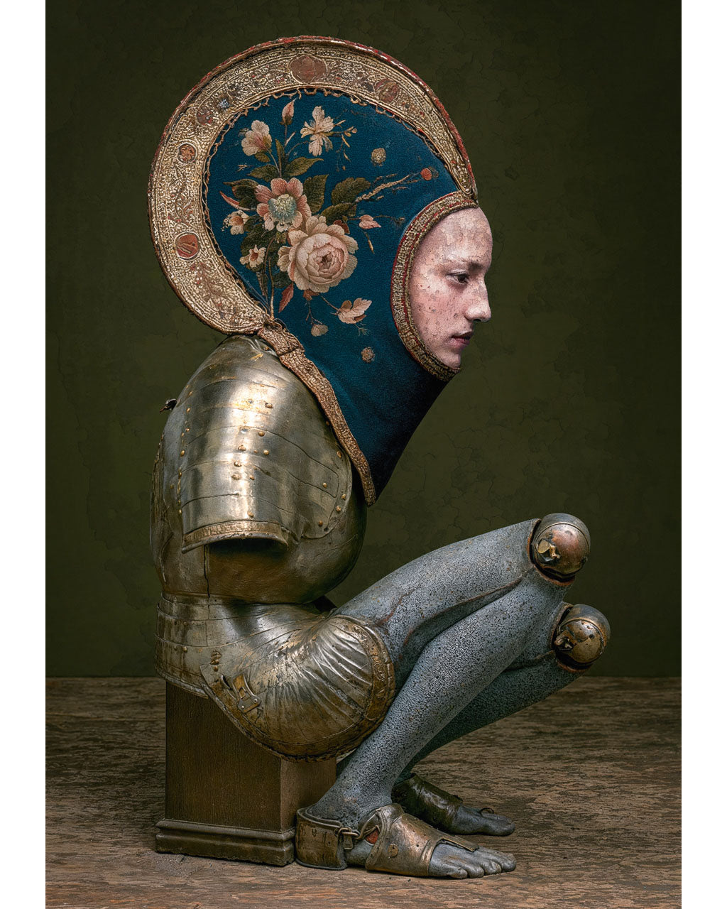 Surreal armoured figure without arms wearing an intricate floral headpiece