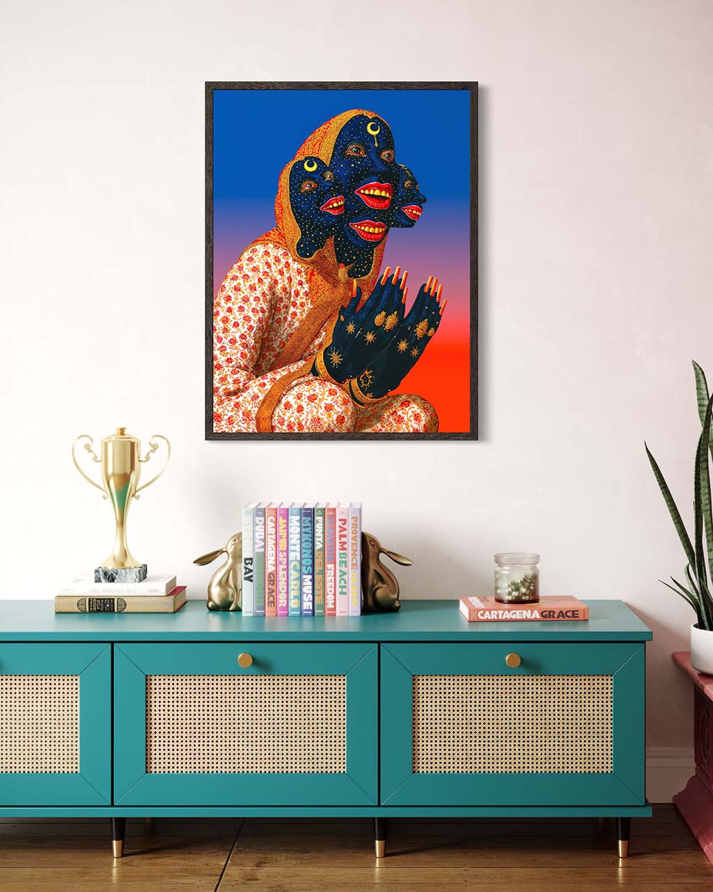 Framed artwork of a stylized figure on a wall above a teal console table with decorative items.