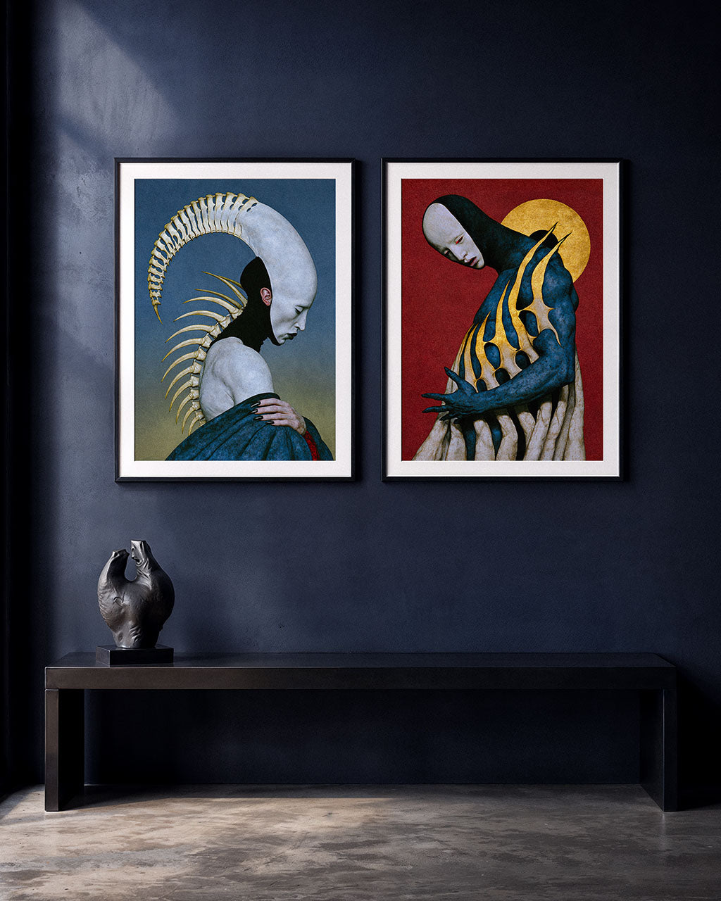 Two surreal art prints, Pleroma and Numina, displayed side by side in black frames on a dark blue wall, above a minimalist black bench.