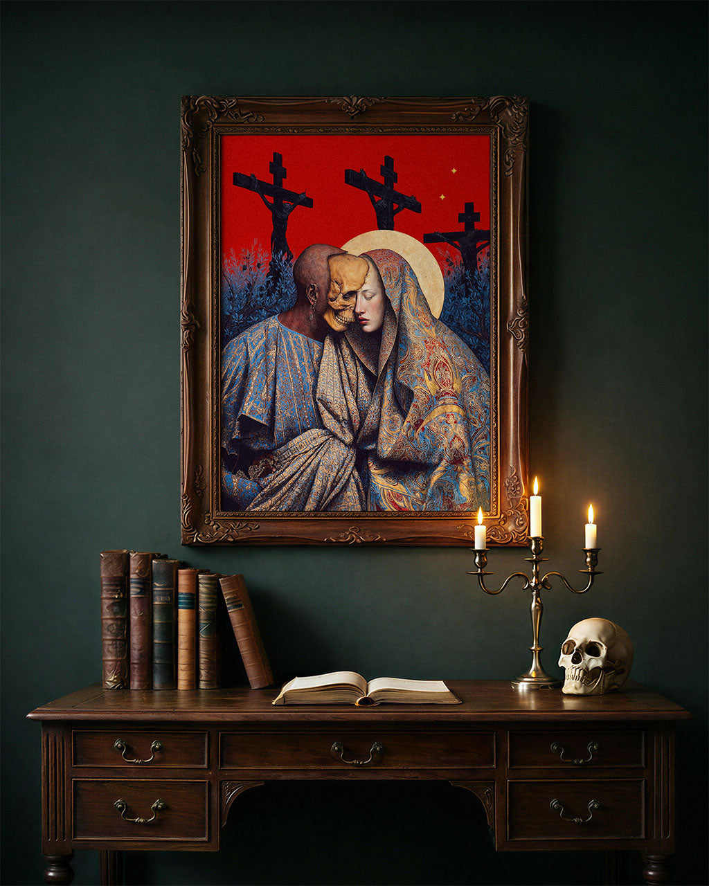 Framed surreal art poster featuring intertwined figures and religious symbolism above a dark wooden desk with candles and a skull.