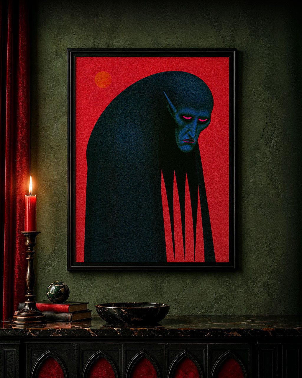 An Uninvited Guest gothic art print displayed in a black frame on an olive-green wall above a dark marble cabinet, surrounded by candlelight, antique books and gothic-inspired decor.